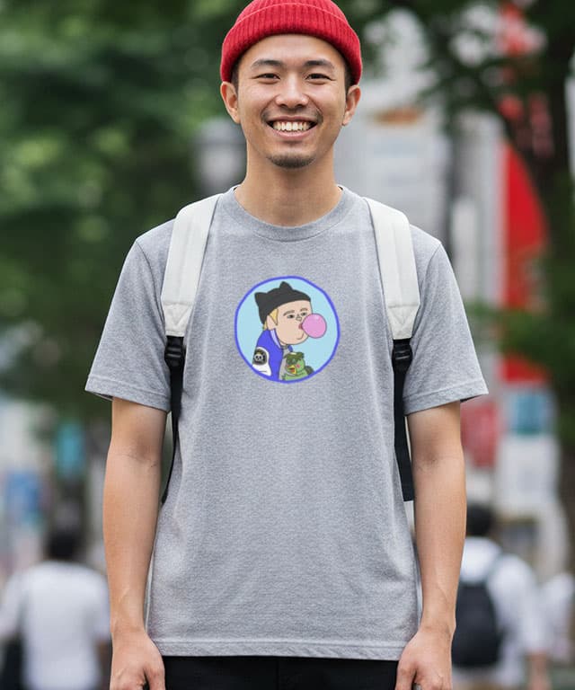 耳付きニットキャップを被った青年 河童の子を抱きながらガムを膨らます - 画像1